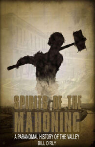 Cover art for Spirits of the Mahoning: A Paranormal History of the Valley by Bill O’Rly, featuring a spectral silhouette of a steelworker with a sledgehammer rising from smoke above an industrial river landscape.
